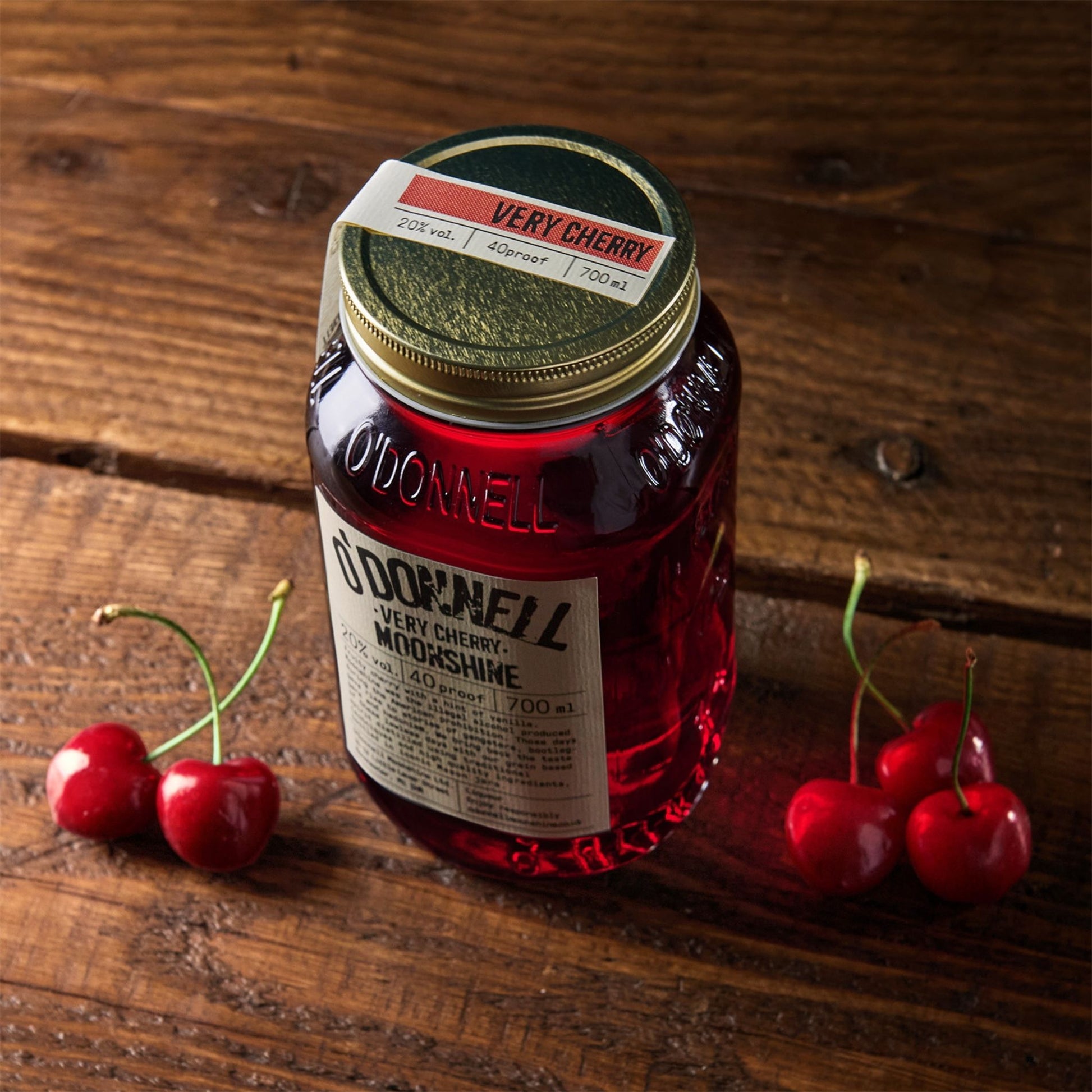 Jar of O'Donnell Very Cherry Moonshine on a wooden surface with cherries.