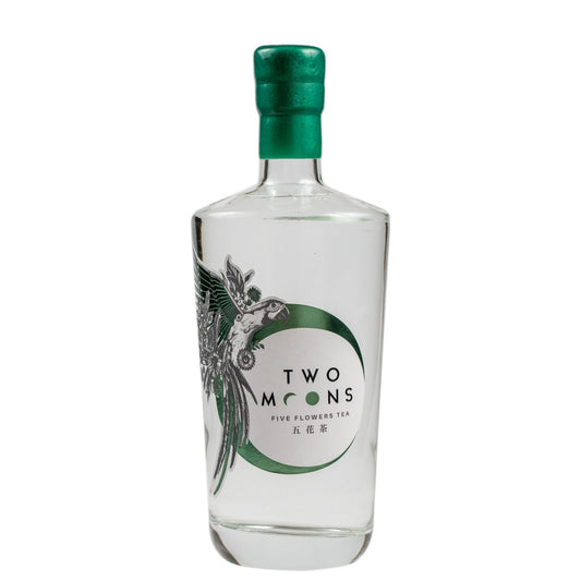 A clear glass bottle of Two Moons Five Flowers Tea with a metallic green cap and a green and white label featuring a bird illustration.
