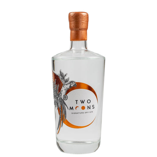 A clear glass bottle of Two Moons Signature Dry Gin with a copper-colored foil stopper and a white label featuring a stylized bird illustration and orange circular design, set against a plain white background.